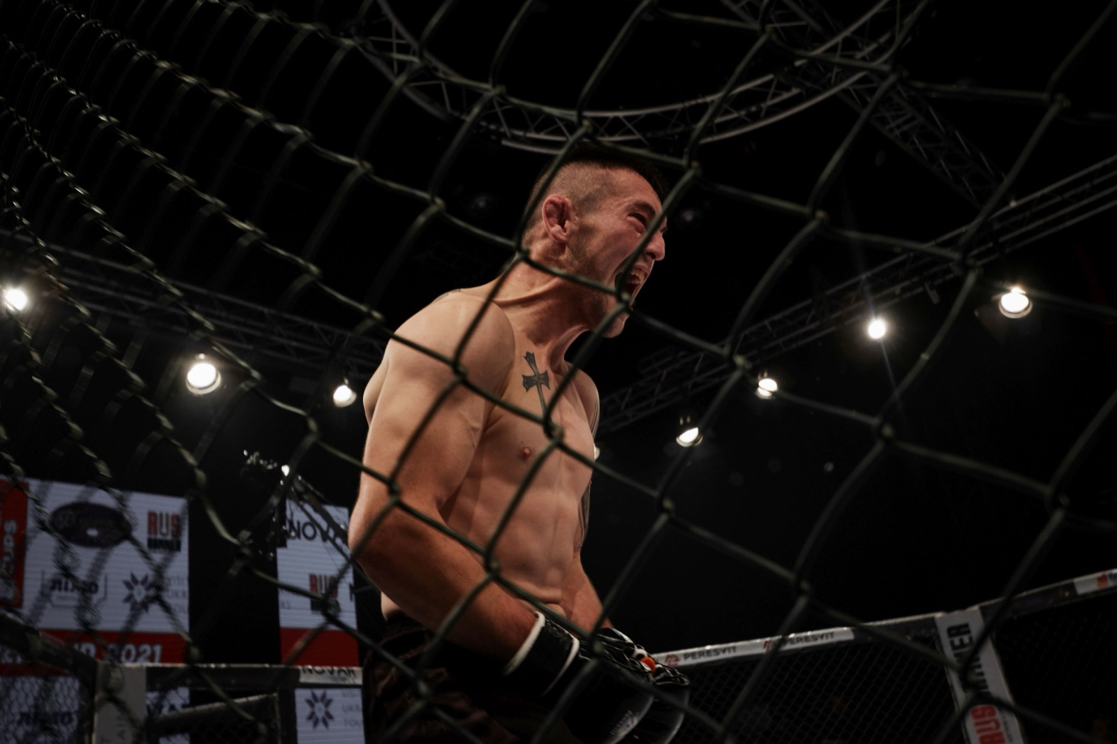 An RFP fighter roars with emotion behind the cage after a decisive moment.